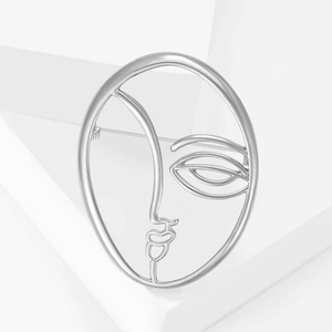 Minimalist silver face profile brooch pin on white geometric background platform