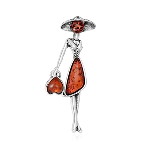 Vintage style brooch of an elegant woman with a wide-brimmed hat and amber gemstone inlay