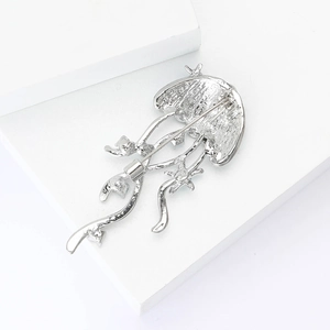 Detailed back view of a silver jellyfish brooch showing the secure safety pin fastener