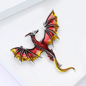 Detailed close-up of a flying dragon brooch with vibrant red and yellow enamel inlay