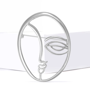 Detail view of the silver abstract face brooch with artistic minimalist metal lines