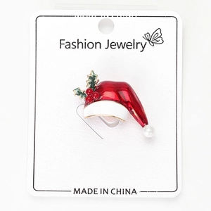 Detail of a red Christmas hat brooch with pearl and holly leaves on a display card