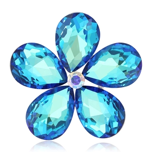 Broche fleur luxueuse avec pétales en cristal bleu et base argentée sur fond blanc