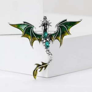 Detail of dragon brooch with green enamel wings and drop-shaped faux gemstones
