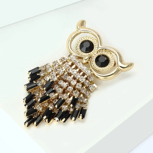 Detailed macro view of owl brooch with gold metal, crystal rhinestones and black stones