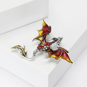 Close-up of vintage silver dragon brooch with red enamel wings and crystal details