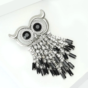 Macro view of owl brooch with sparkling rhinestones and elegant black tassel fringe