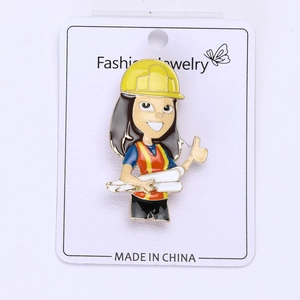 Detail of female engineer enamel pin with yellow hard hat and red vest on display card