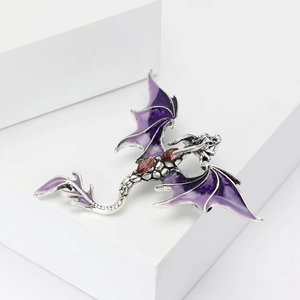Detail of silver dragon brooch featuring purple enamel wings and brown gemstone inlay