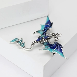 Detailed macro view of silver western dragon brooch with blue enamel wings and gems