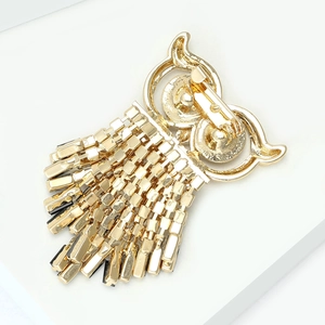 Detailed back view of gold owl brooch featuring needle clasp and metal chain tassels