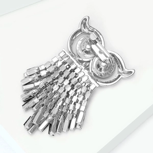 Detail view of owl brooch back with safety pin clasp and silver tassel design
