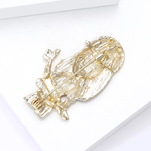 Creative golden engineer brooch with secure pin back on white leather surface