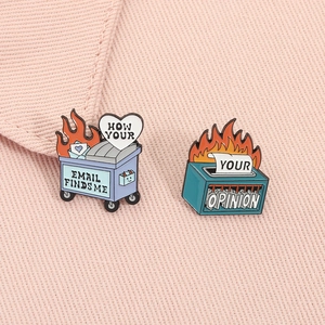 Macro view of office humor enamel pins showing burning trash and shredding files