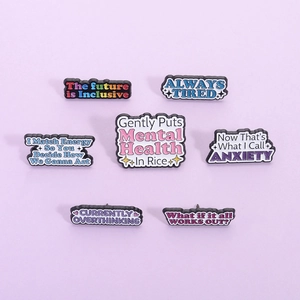 Set of 7 colorful mental health enamel pins with motivational quotes on purple background