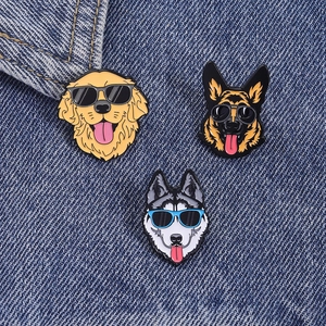Détail de pins de chiens avec lunettes de soleil sur fond de tissu denim bleu