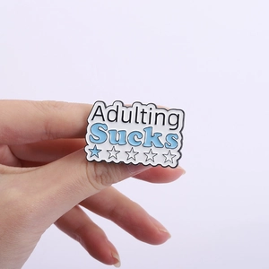 Détail du badge émaillé Adulting Sucks avec évaluation d'une étoile sur forme de nuage