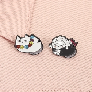 Detailed close-up of funny enamel pins featuring a fat cat in a wig and flower wreath