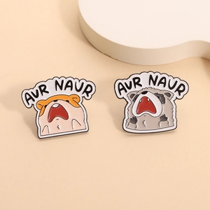 Cute enamel pins featuring a screaming hamster and raccoon with AUR NAUR text