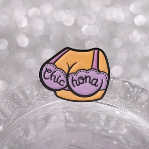 Close-up of enamel bra brooch with Chic hona lettering and purple lace details