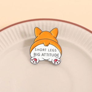 Niedliche Corgi-Emaille-Anstecknadel mit Spruch auf beige Keramikteller präsentiert