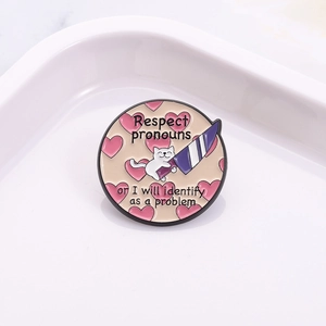 Cute enamel cat pin with Respect Pronouns text and purple knife on white ceramic plate
