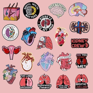 Set di 20 spille in smalto con organi anatomici tra cui cuore, cervello e polmoni su rosa