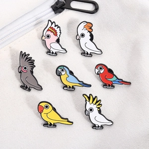 Lot de 7 broches perroquet cartoon colorées sur fond de sac en toile blanche