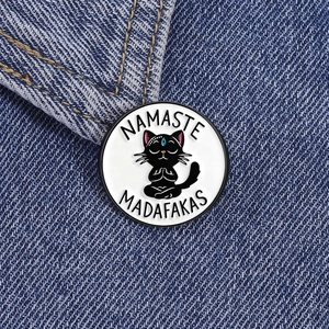 Detail der Namaste Madafakas Emaille-Anstecknadel mit schwarzer Katze auf Denim