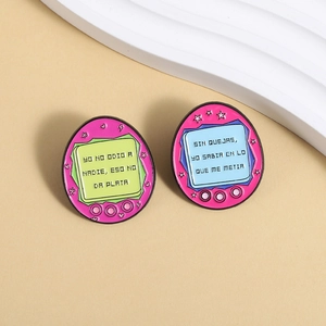 Detail view of pink retro handheld game console enamel pins with humorous Spanish quotes