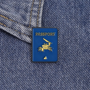 Close-up of a blue enamel passport pin with a funny crab on denim fabric background