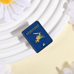 Close-up of blue enamel passport crab brooch with golden details on a white display tray