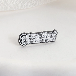 Feminist enamel pin badge with If You Cut Off My Reproductive Choice phrase on white fabric