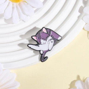 Close-up of a cute purple and white enamel cat pin on a white decorative floral tray