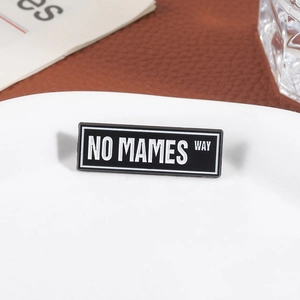 Minimalist black rectangular enamel brooch with white No Mames Way slogan lettering