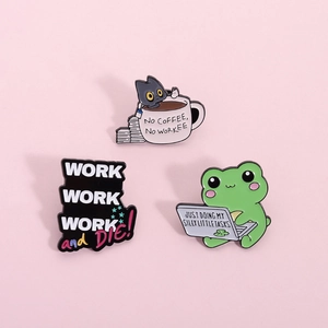 Detailed view of cartoon enamel pins with humorous work-themed text on a pink background