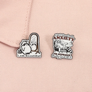 Détail de pin's émaillés mignons avec illustrations de raton laveur et chat sur col rose