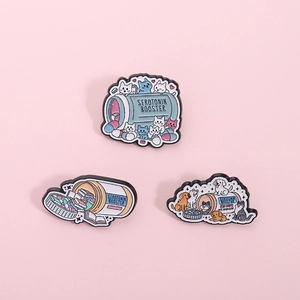Detail von drei Emaille-Pins mit süßen Katzen-, Hunde- und Pillenflaschendesigns