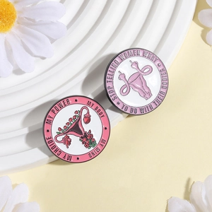 Détail macro de broches féministes émaillées avec slogans sur plateau blanc