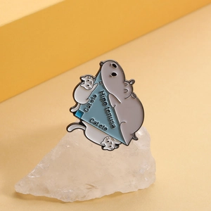 Detailed close-up of cute enamel hippo and cat geometry brooch on a stone prop