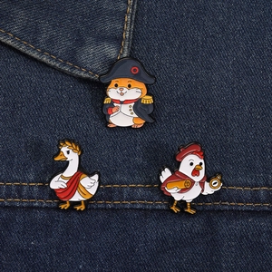 Close-up of enamel badges showing hamster, goose, and rooster as historical figures on denim