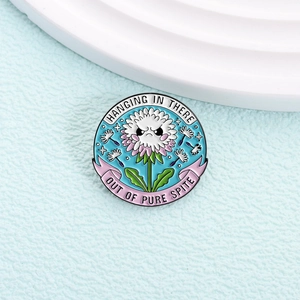 Cute dandelion enamel pin featuring a stubborn expression on light blue background