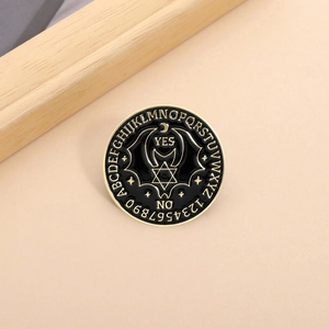 Gothic Ouija enamel pin with bat and moon design in black and gold finish