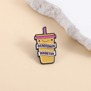 Cute yellow enamel pin in a cartoon drink cup shape with Serotonin Booster text design