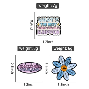 Détail des épinglettes en émail avec citations motivantes et motifs de marguerites