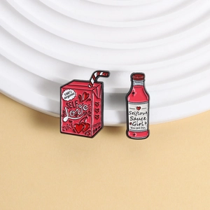 Pink cartoon enamel pins set featuring self love juice box and bottle on white display