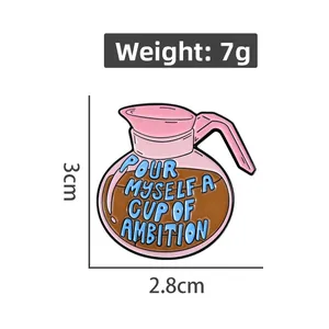 Detail of pink coffee pot enamel pin with 'Pour myself a cup of ambition' text and dimensions