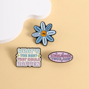 Set di tre spille motivazionali in smalto con forme di fiori e citazioni ispiratrici