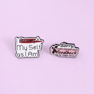 Macro view of inspirational enamel pins featuring I Accept My Self text and slogans