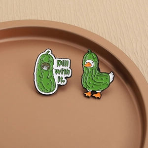 Dettaglio delle spille smaltate gatto e anatra sottaceto con testo Dill with it